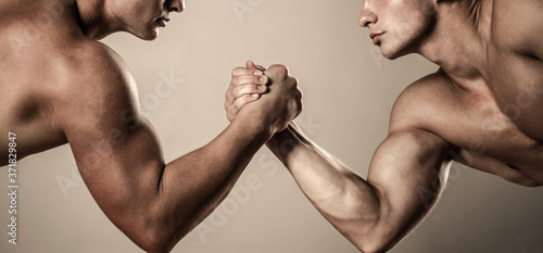 Two hands. Muscular men measuring forces, arms. Hand wrestling, compete. Hands or arms of man. Muscular hand. Clasped arm wrestling