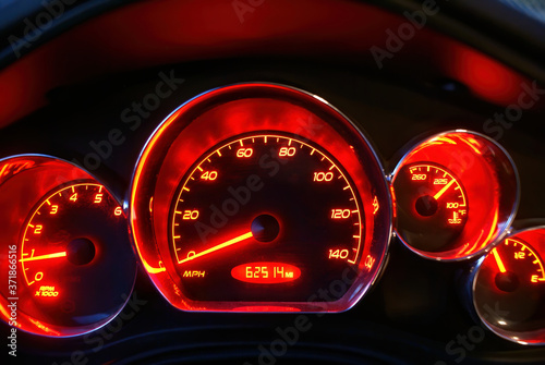 The glowing red speedometer of a Pontiac G6 with emblems removed.