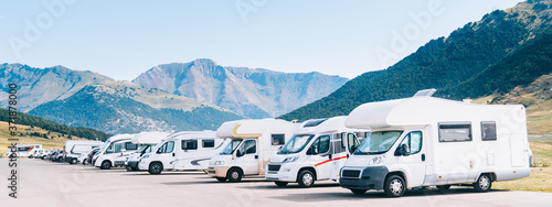 Summer tourism with RV. Campers parked in a row in a caravan parking area. Best option for travel in times of coronavirus pandemic.