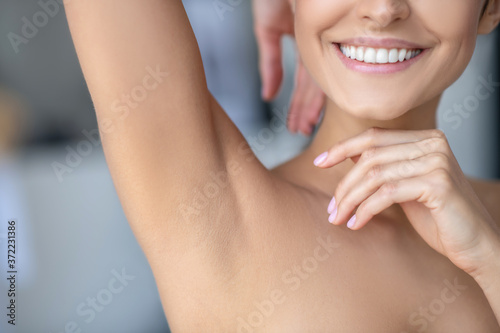 Smiling woman showing her shaved underarm