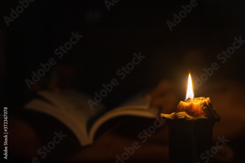 Reading a book in the dark by candlelight