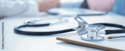 Stethoscope and clip board on the doctor workplace close up