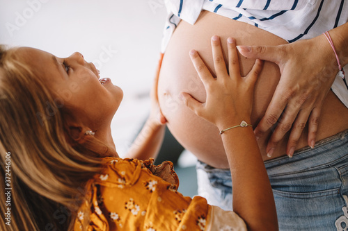 Beautiful pregnant woman with cute daughter. Pregnancy, family, love concept.