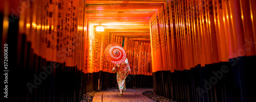 Japanese girl in Yukata with red umbrella at Fushimi Inari Shrine