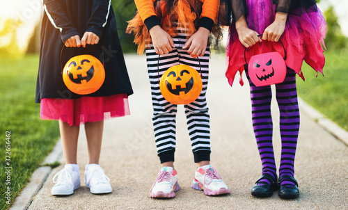 Happy Halloween! legs of funny children in carnival costumes outdoors