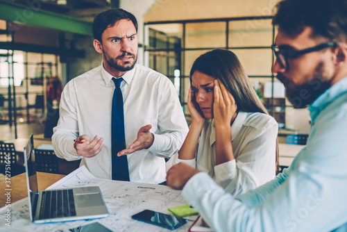 Angry coach disappointed with work of team talking about problems with financial report, male and female members of working group quarreling during collaboration fail with software updating on laptop