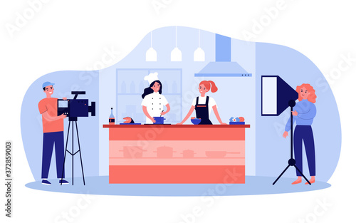 Popular cooking show concept. Camera man and stage manager shooting smiling chefs cooking and talking at kitchen counter. For TV show production, television, coking contest topics