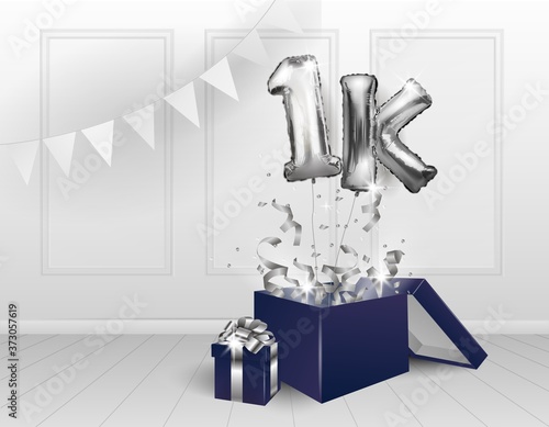 1k one thousand subscribers.Silver balloons. The celebration of the anniversary. Balloons with sparkling confetti fly out of the box, number 1 against the wall. Birthday or wedding decorations.