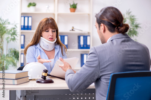 Young injured woman and male lawyer in the courtroom