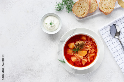 traditional Russian Ukrainian red borscht. soup with beets, cabbage, potatoes and meat, served with sour cream and herbs. top view. White background. copy space