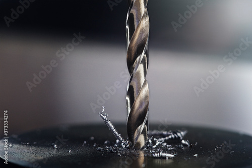 metal drill bit make holes in steel billet on industrial drilling machine. Metal work industry. multi cutting tool and end mill.