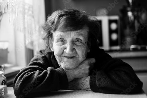 Close-up black and white portrait of an happy old woman.