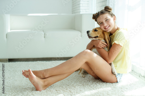 Child with a dog. Teenage girl with a beagle dog at home. High quality photo.