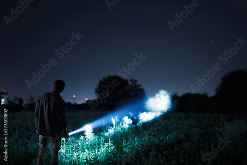 Person with flashlight at night