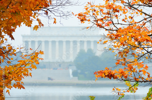 Autumn foliage and Washington D.C. - Lincoln memorial and Potomac River among autumn maple trees.