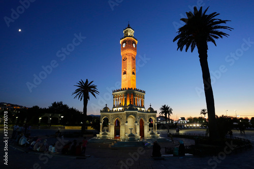The iconic Clock tower is seen illuminated at Konak district during a beautiful sunset in the coastal city of Izmir, Turkey.