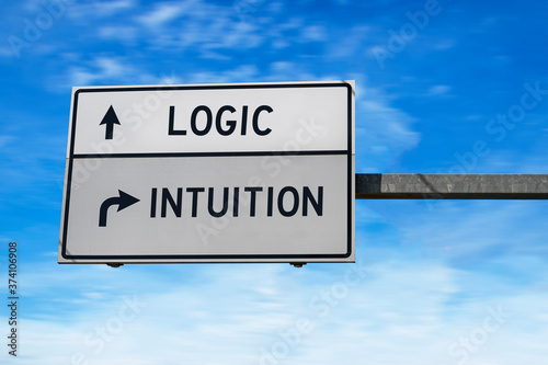 Logic versus intuition. White two street signs with arrow on metal pole. Directional road. Crossroads Road Sign, Two Arrow. Blue sky background.