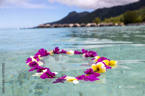 Colorful flower lei floats in turquoise water on an exotic tropical island