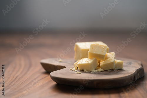 White cheddar cheese pieces on olive wood board