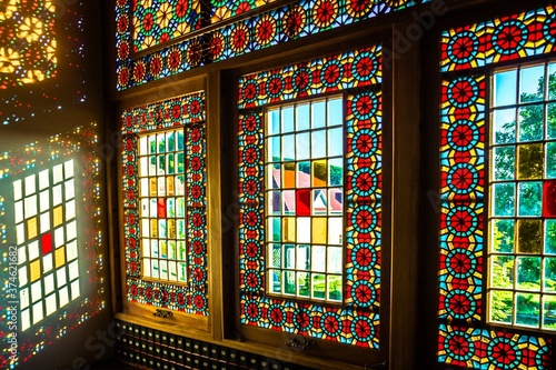 Sunlight through the stained glass window in the Palace of Shaki Khans, Azerbaijan. Vibrant spots on the wall in a pattern.