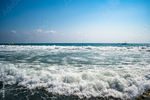 Beautiful sea waves splash with white foam on a blue ocean surface background.