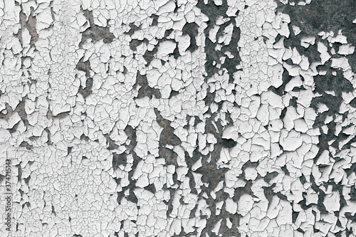 Old cracked paint texture. White paint on black surface.