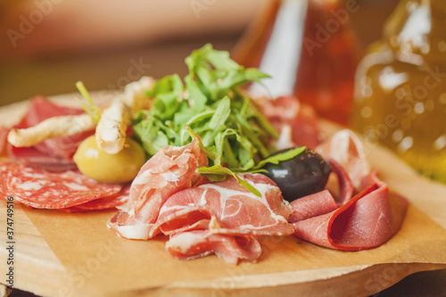 Charcuterie board with prosciutto ham, salami, herbs and olive antipasti. Gourmet platters