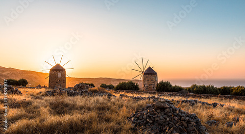 Meditterranean lanscape with two old windmills by amazing sunset