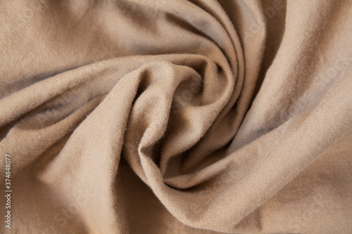 The texture of crumpled beige soft warm fabric. Flannel.