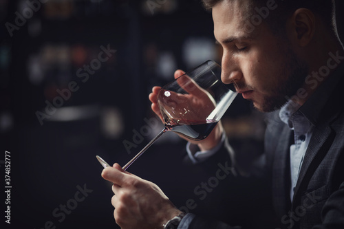 Sommeliers male hold glass red wine tasting degustation card