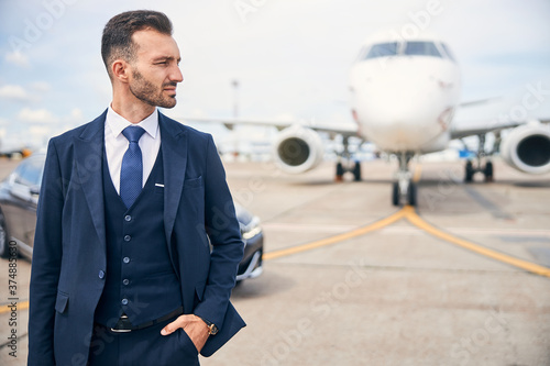 Young businessman posing in front of a plane
