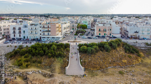 Aerial view of Polignano a Mare, a village built on the edge of the cliffs above the Adriatic Sea in Apulia, Italy - Stairs leading from the Domenico Modugno statue to the Pietra Piatta viewpoint