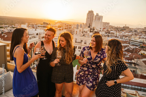 Group of young friends drinking wine during sunset in Madrid