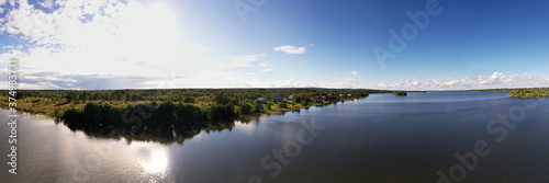 panoramic view of the island with old wooden buildings on the lake filmed from a drone