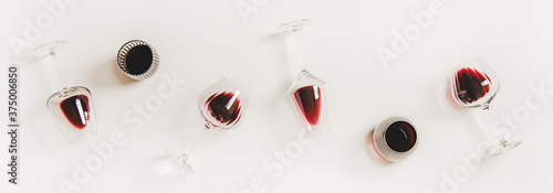 Red wine in glasses. Flat-lay of wine glasses with red wine in row over plain white background, top view. Wine tasting, winery, bar or Beaujolais Nouveau concept