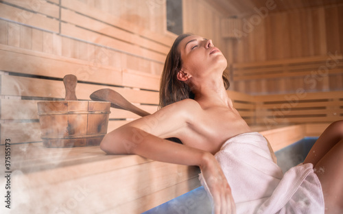 Beautiful young woman relaxing in Finnish sauna