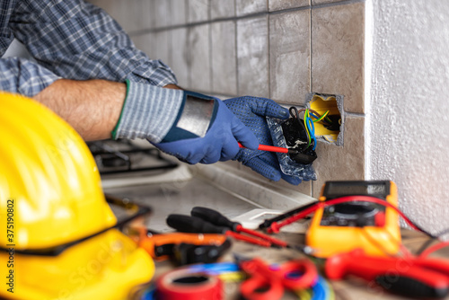 Electrician at work with safety equipment on a residential electrical system. Electricity.