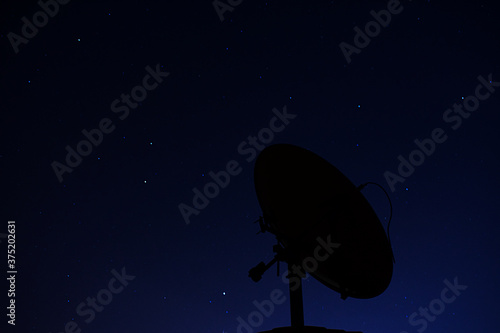 Antena con el cielo de noche de fondo. Tonos azulados y estrellas