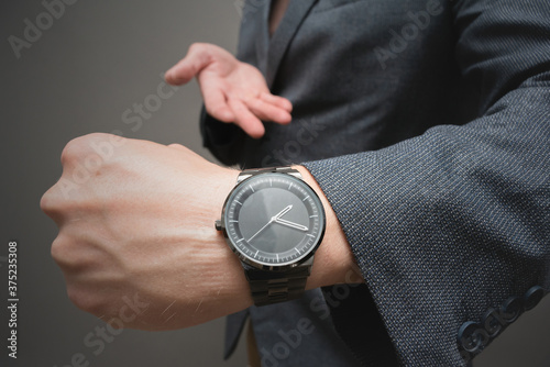 A wrist watch on the businessman hand close up.