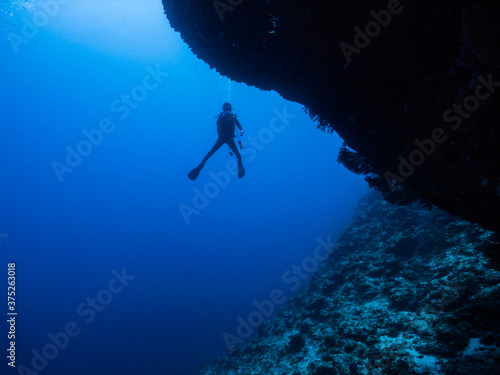青い海を背景に中性浮力を保つダイバーのシルエット。沖縄県伊江島