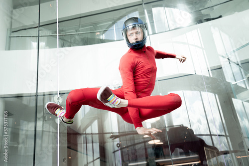 Man in a red suit, portrait of a skydiver. levitation of sports people in a wind tunnel. jumping without a parachute in a wind tunnel indoors.