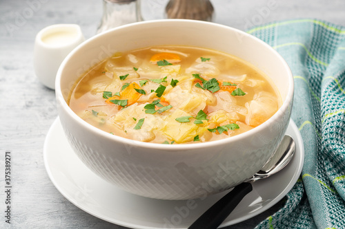 Homemade cabbage soup in bowl on concrete background