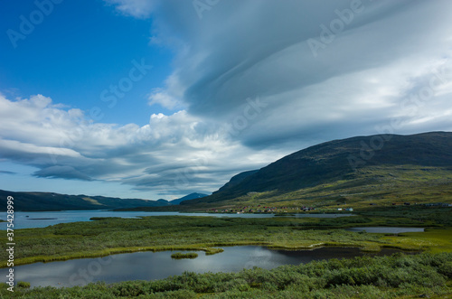 Swedish Lapland landscape. Lake Alisjavri on Kungsleden and Nordkalottruta Arctic hiking Trail in northern Sweden. Arctic environment of Scandinavia in summer day with unusual cloud formation