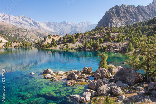 Tajikistan. Turquoise water in Alaudin lake. Beautiful view on rocky shore of lake in Fann mountains. 