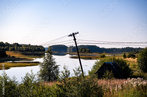 rural landscape in the morning with wooden houses and electric pillars
