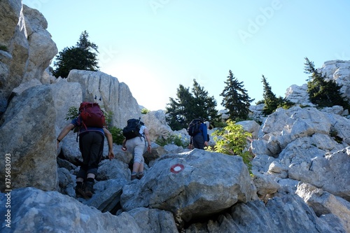 The beautiful Premuziceva Staza mountain path, Velebit National Park, Dinaric Mountains, Croatia. Silhouette of climbing tourists among rocks.