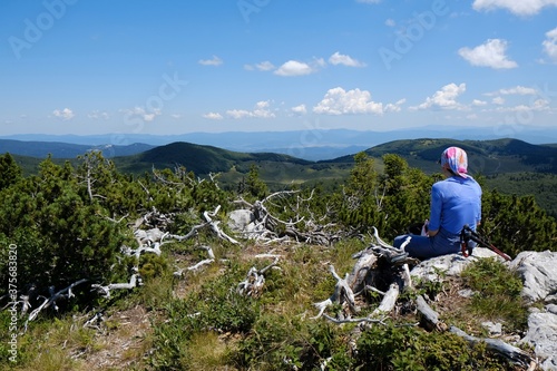 The beautiful Premuziceva Staza mountain path, Velebit National Park, Dinaric Mountains, Croatia. Silhouette of resting tourist on Veliki Zavizan peak. 