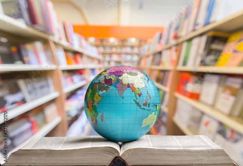 Heavy book and globe planet on library background
