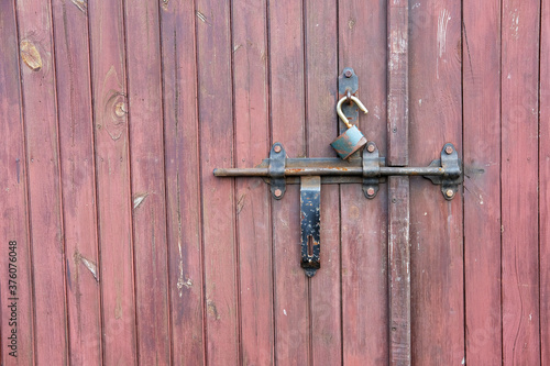 Vintage wooden garage door wth padlock and old metal hasp