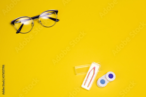 Fashionable glasses and lenses for vision on a yellow background. Vision correction. Glasses for sight. Optics. Copy spase